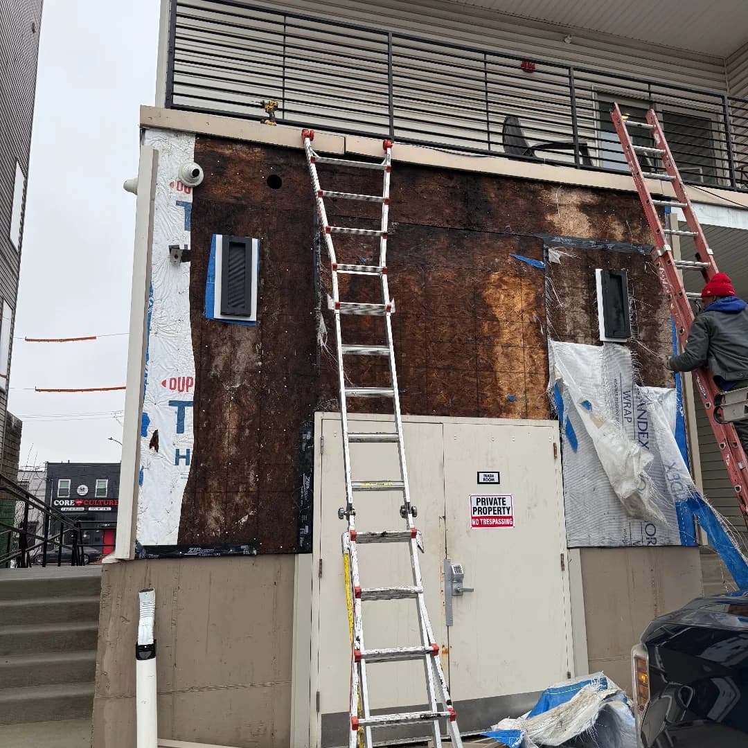Commercial building with siding stripped back to sheathing during replacement