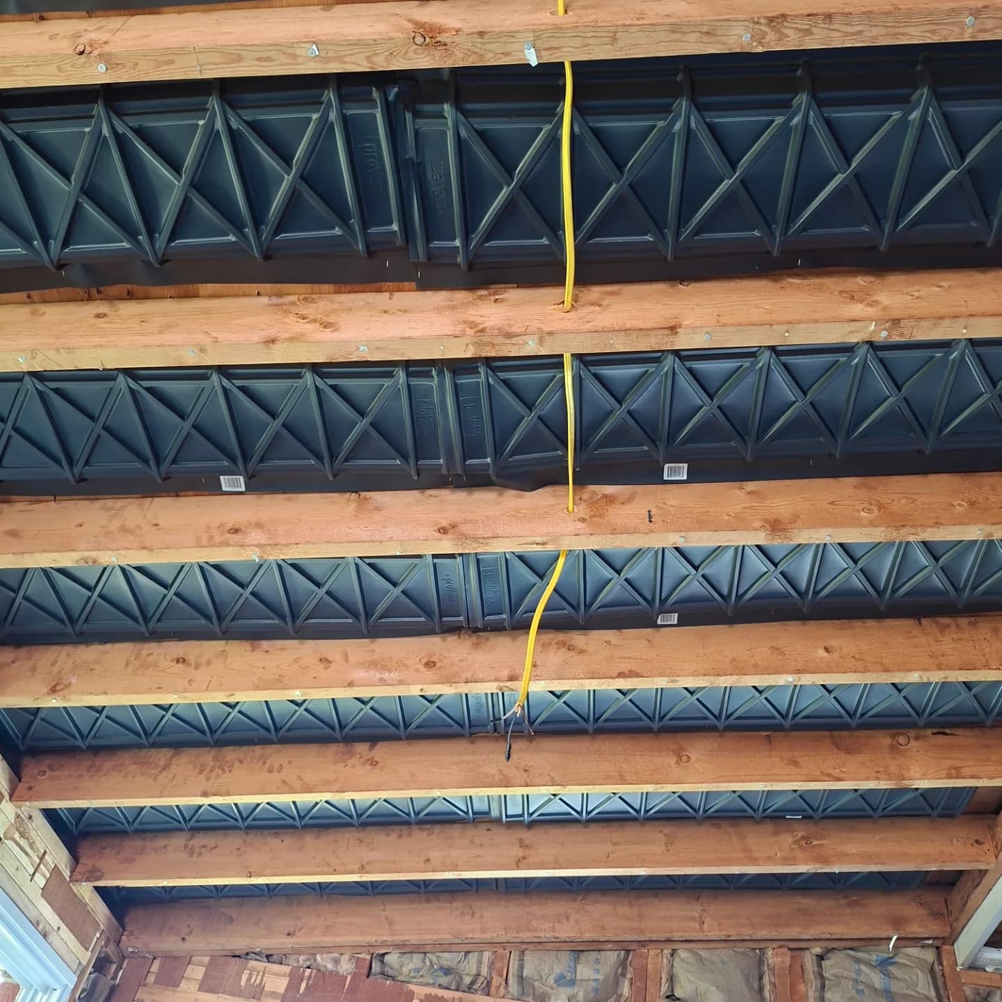Open floor joists with insulated ductwork running between them