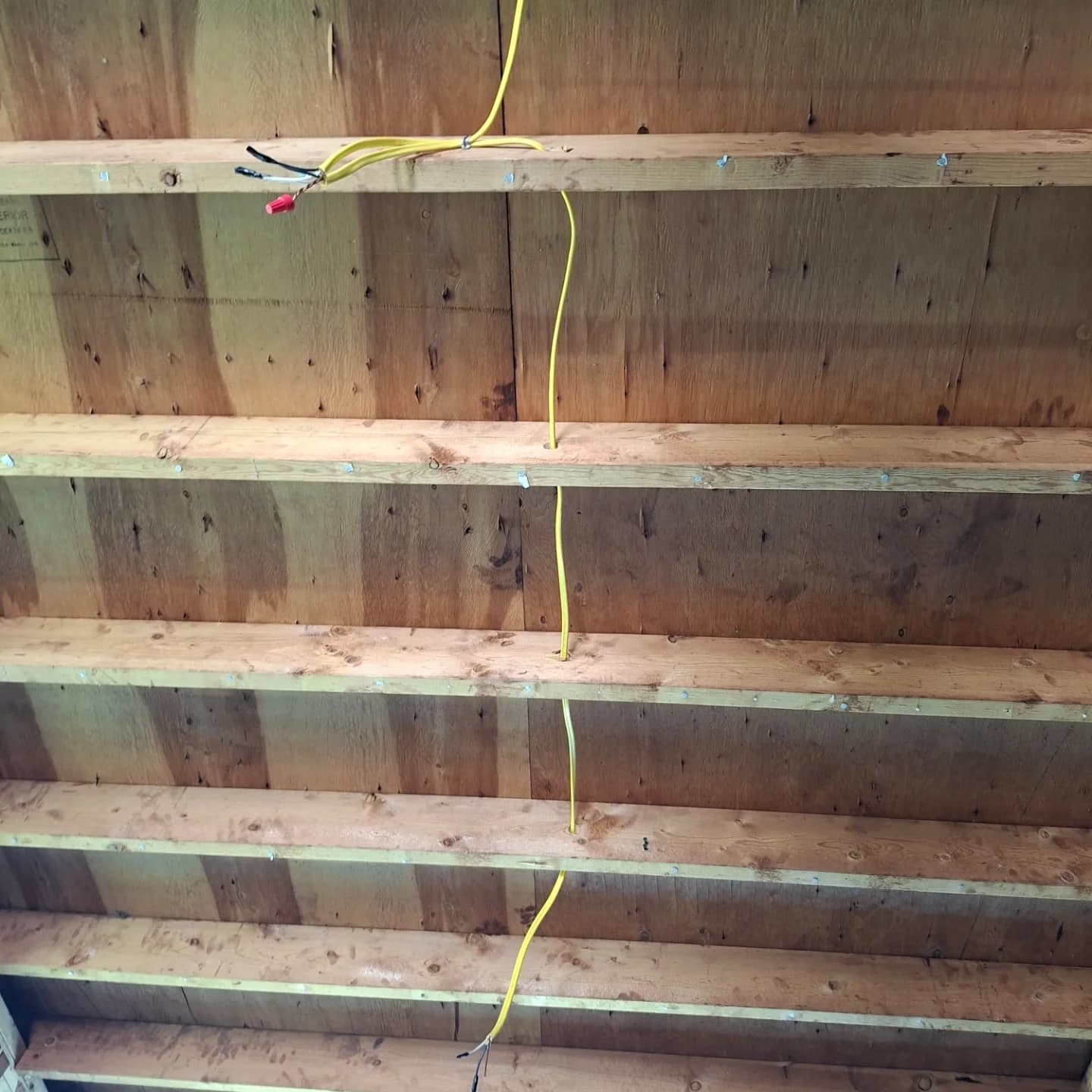 Ceiling joists with new electrical wiring run through the framing