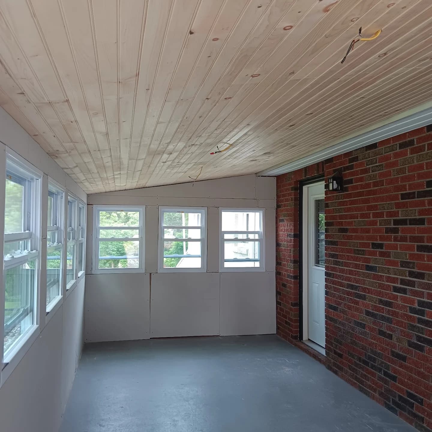 Porch enclosure with tongue-and-groove pine ceiling and new windows